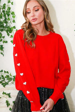 Red sweater with hearts on sleeve